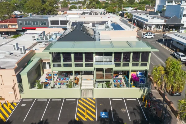 Drone image of the back of the newly refurbished Corrimal Hotel, showing the new outdoor dining area with the large television screen, new staircase and new children's play area.
